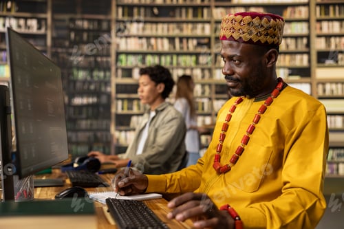 Preview: Adult learner taking notes beside AI chatbot screen in library