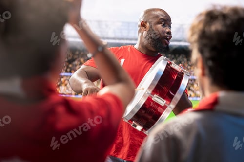 Preview: Football supporter beats drum among cheering fans in stadium