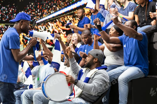 Preview: Black football supporter leading blue stadium chants with drum and megaphone