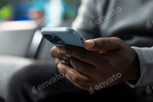 Preview: Close up of black passenger checking social media on smartphone in bus station