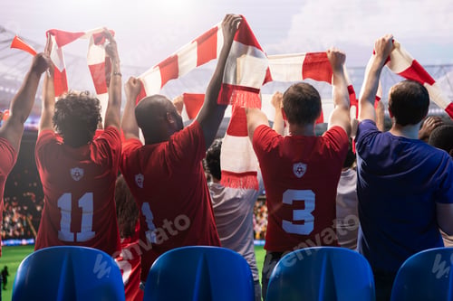 Preview: Back view of football supporters in stadium grandstands lifting scarf