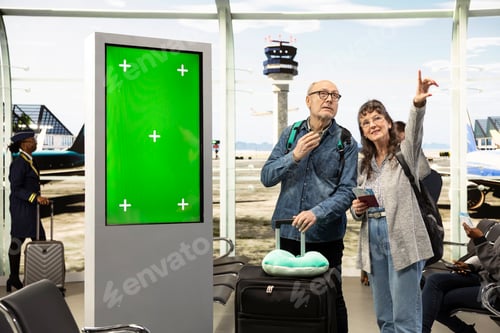 Preview: Green screen mockup on airport screen next to senior couple in airport lounge