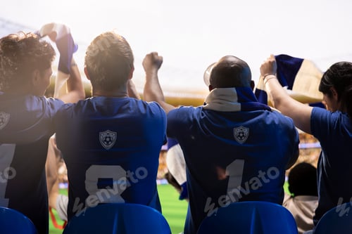 Preview: Rear view of supporters raising fists during football match