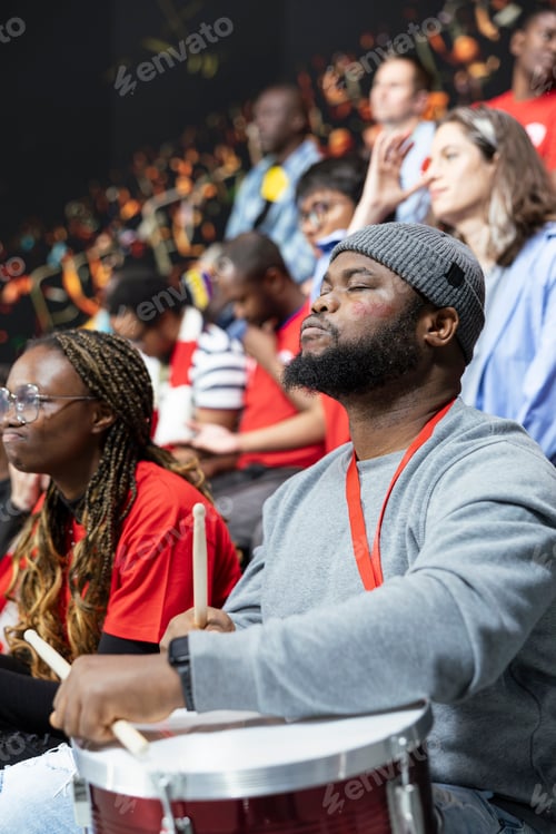 Preview: Vertical portrait of Black football supporter with gray beanie closing eyes