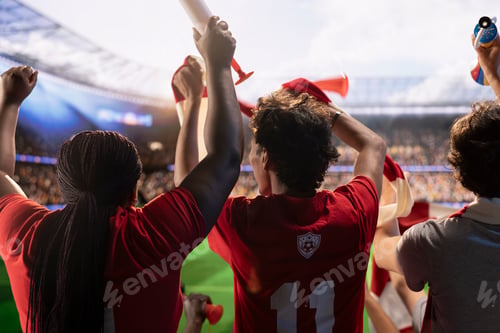 Preview: Football supporters in red team kit raising hands holding scarves
