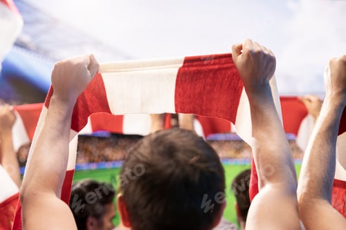Preview: Close up of football supporter holding red and white scarf in stadium