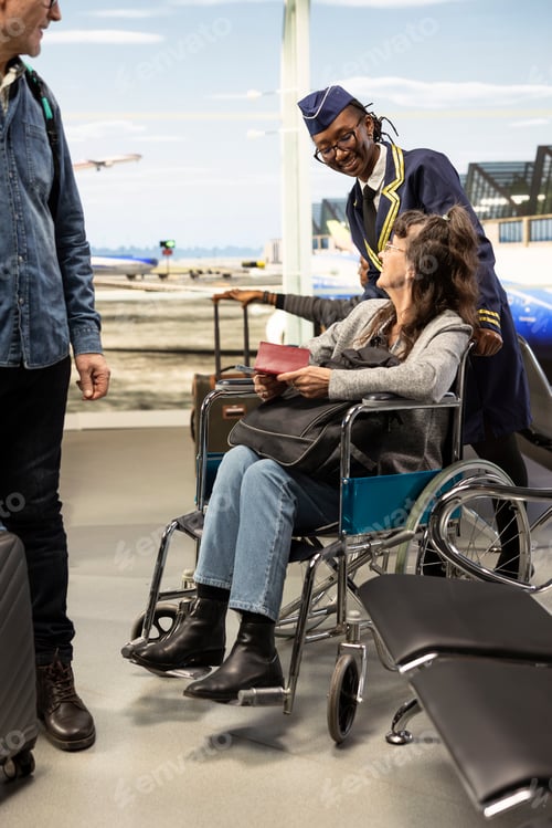 Preview: Professional flight attendant assisting elderly woman by pushing wheelchair user