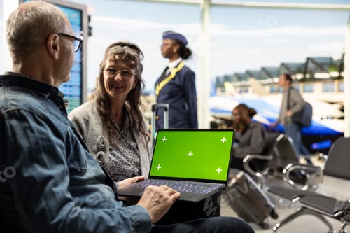 Preview: Chroma key on laptop screen used by senior people in airport lounge