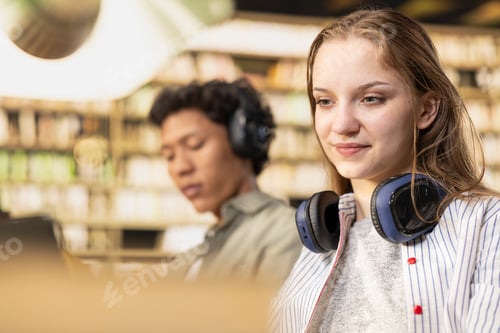 Preview: Close up of student with headphones around her neck using laptop