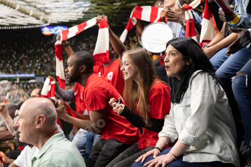 Preview: Focused football supporters watching dramatic final minutes of a soccer match