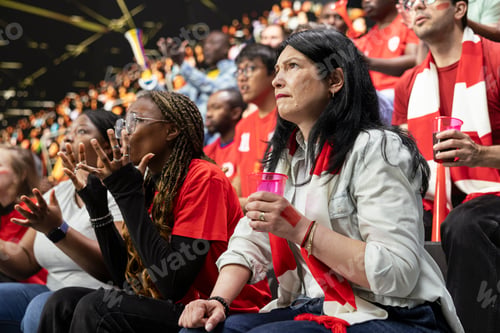 Preview: Red team football supporters reacting with anxious gestures in stadium stands