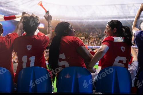 Preview: Female soccer supporters in red team shirts excited by goals scored