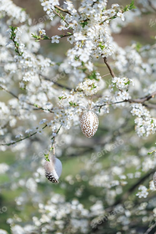 Preview: Golden Easter egg and feather egg on spring blossom tree