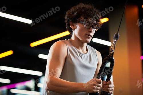 Preview: Teenage Boy Exercising on Cable Machine for Fitness Training