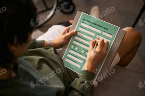 Preview: Adult Man Completing Health Insurance Claim Form at Home