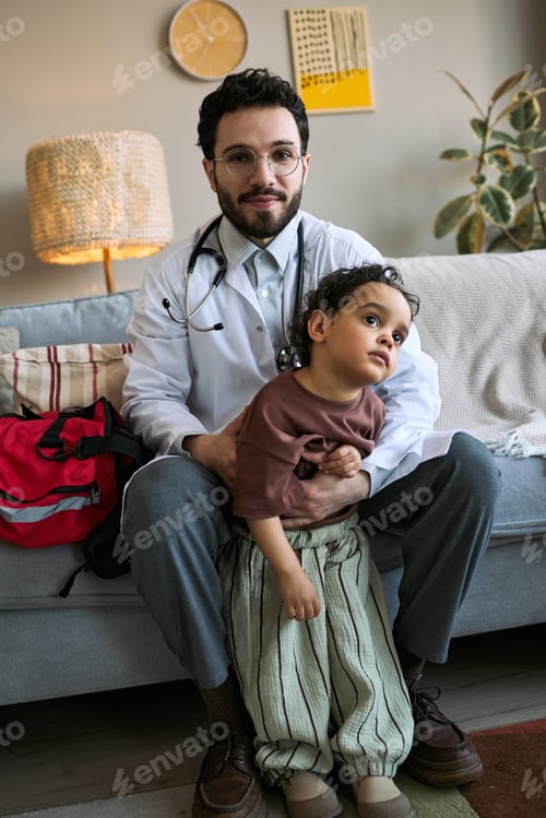 Preview: Portrait of Male Doctor Examining Child during Home Visit Care