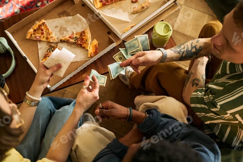 Preview: Diverse Friends Splitting Pizza Bill with Cash for Shared Meal