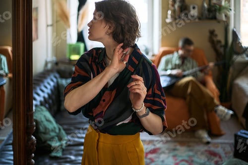 Preview: Adult Woman Adjusting Earring at Home during Creative Leisure