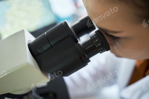 Preview: Adult Woman Examining Samples through Microscope in Laboratory