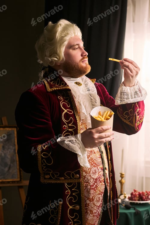 Preview: Man in Historical Costume Holding French Fries for Humor Concept