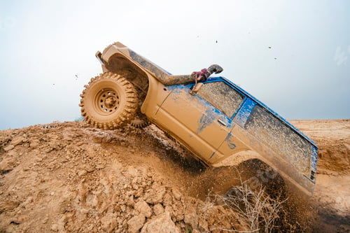 Preview: Off-road vehicle climbing dirt track with splashing mud
