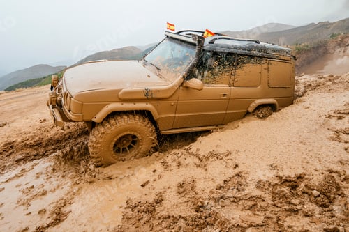 Preview: Off-road vehicle driving through muddy terrain in mountains