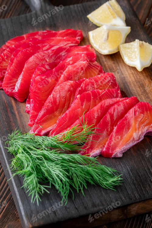 Preview: Slices of Fresh Cured Salmon with Lemon and Dill on Wooden Board