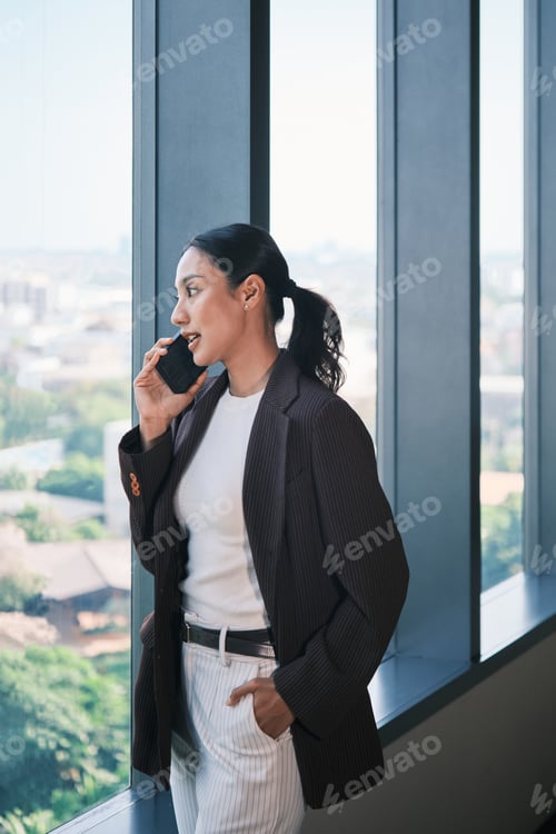 Preview: Professional Woman Talking on Mobile Phone in Modern Office