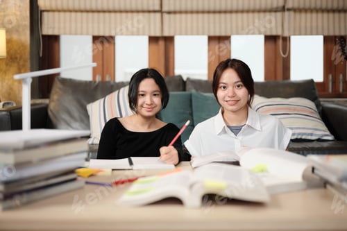 Preview: Two Asian teenage girls studying at home together, tutorials for education exam.