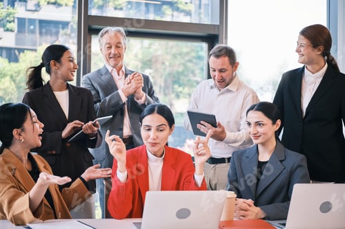 Preview: Professionals Celebrating Success During an Office Meeting Around a Laptop
