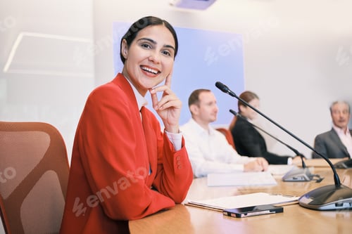Preview: Hispanic woman speaker in a group of businesspeople at a seminar event.