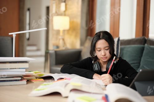 Preview: Asian teenage girl studying at home, preparing for university.