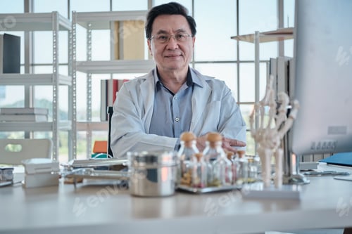 Preview: Portrait of professional senior Asian doctor, happy working in hospital office.