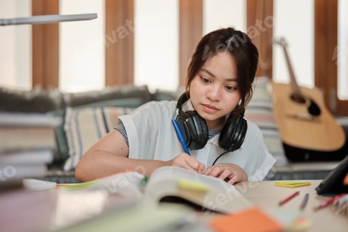 Preview: Asian teenage girl studying at home, preparing for university.