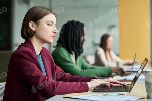 Preview: Adult Businesswoman Working on Laptop in Collaborative Office