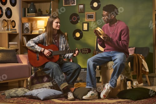 Preview: Teenage Girl and Black Teenage Boy Playing Music at Home
