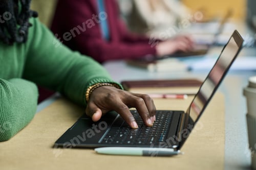 Preview: Black Woman Typing on Laptop in Collaborative Office Workspace