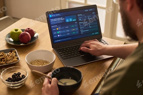 Preview: Man Tracking Diabetes Nutrition Data on Laptop at Home