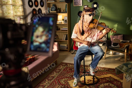 Preview: Young Man Playing Violin While Recording Music Content at Home