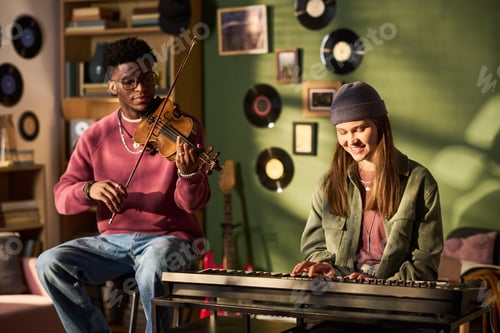 Preview: Black Man Playing Violin While Young Woman Practicing Keyboard