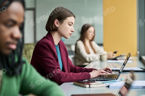 Preview: Adult Woman Working on Laptop in Shared Office Environment