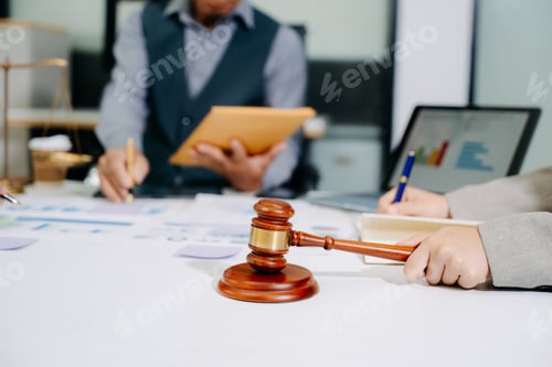Preview: Business and lawyers discussing contract papers with brass scale on desk in office. Law, legal servi