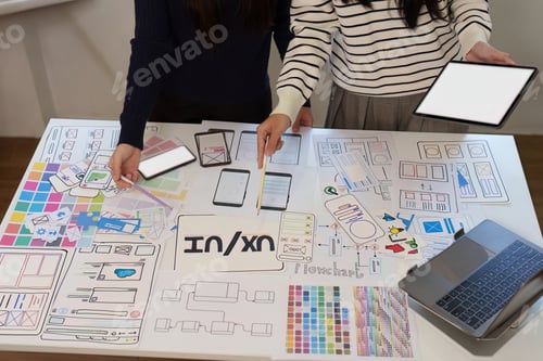 Preview: UX UI designers collaborating on mobile app wireframe templates in office