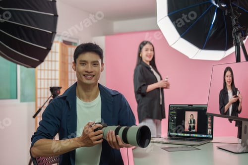 Preview: Asian photographer holding camera in studio for behind the scenes photoshoot