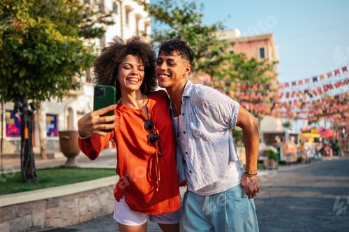 Preview: Young students relaxing and enjoying a city break, using their mobile phone to capture a moment