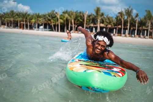Preview: Young multiethnic people, couple having fun on surfboards in the clear ocean water during summer
