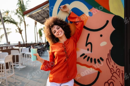Preview: Successful woman embracing a feeling of liberation, standing confidently against vibrant street art