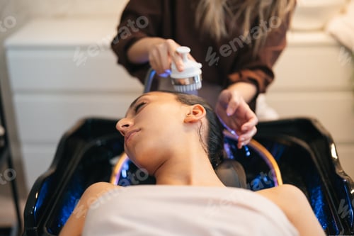 Preview: Side view of woman having hair washed in salon