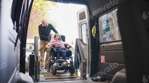 Preview: Caregiver assisting man in wheelchair entering accessible van