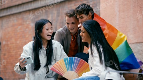 Preview: Diverse friends celebrating pride month with rainbow fan